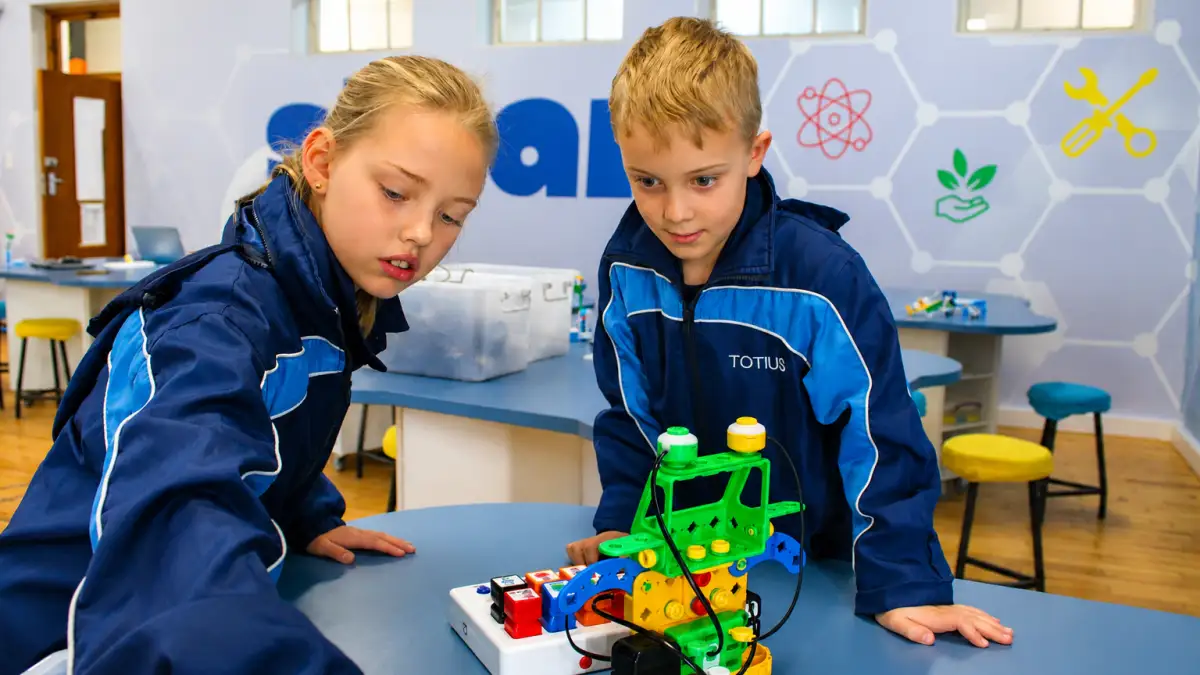 Twee Totius-leerders werk saam aan 'n kleurvolle robotikaprojek